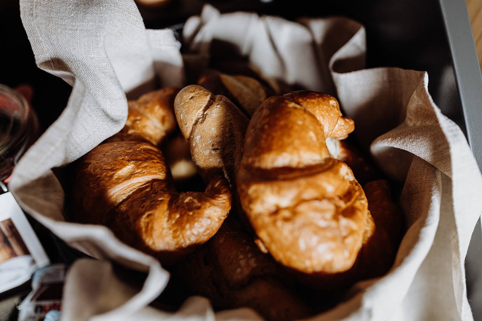 croissants und weckerl im brotkorb beim frühstück am ebengut