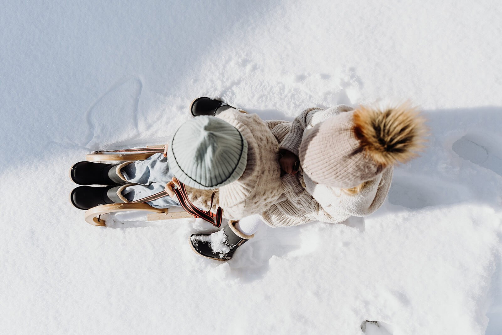 zwei kinder auf einem schlitten in den bergen vom hochkönig